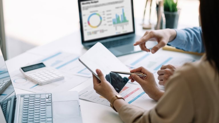 two accounting professionals sitting at a table with a laptop and papers