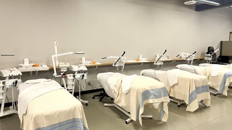 A row of esthetician beds with facial machines and lamps in Bryan College's Student Spa and Esthetic Clinic