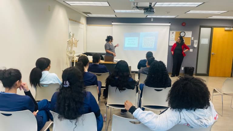 A Dermalogica standing in front of a classroom speaks to students