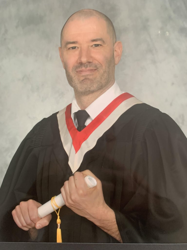 a person in a graduation gown holding a diploma