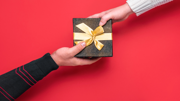 a person giving a gift to another person on a red background